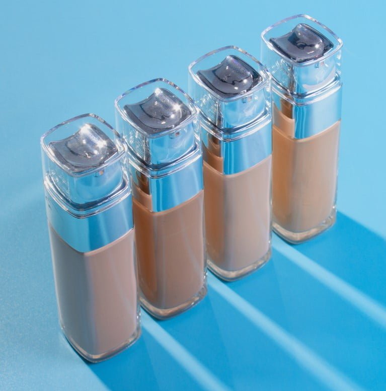 Envase-bases-de-maquillaje-liquido-sobre-fondo-azul