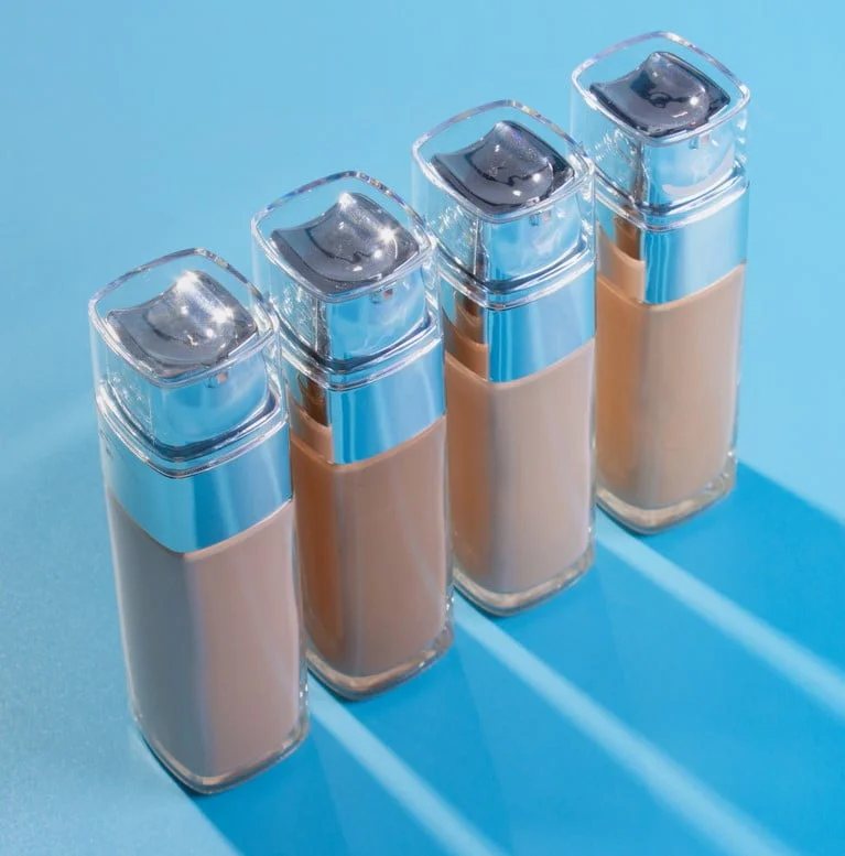 Envase-bases-de-maquillaje-liquido-sobre-fondo-azul