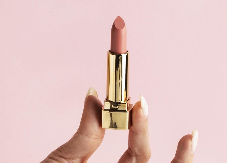 Pintalabios-nude-con-mano-y-con-fondo-rosa