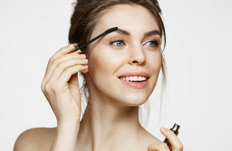 Chica aplicando en las cejas gel para cejas