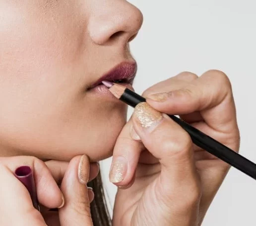 Chica delineándose los labios