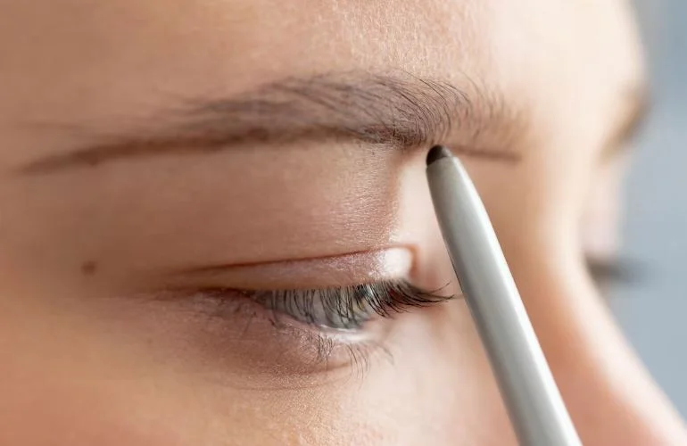 Lápiz de cejas en ojo de chica. Maquillaje para cejas: desde lápices hasta geles