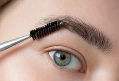 Ojo de mujer con un peine de cejas 