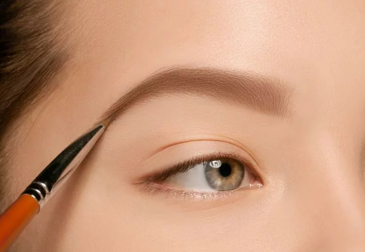 Ojos femeninos con maquillaje ceja y pincel. Maquillaje para cejas increíbles