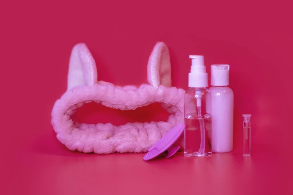 Set de limpieza facial en tomos rosas sobre fondo fucsia.